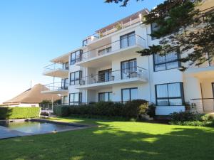 an apartment building with a yard and a swimming pool at 74 on Marine in Hermanus