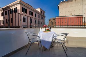 a young girl sitting at a table in front of a building at Hotel Balilla in Rome