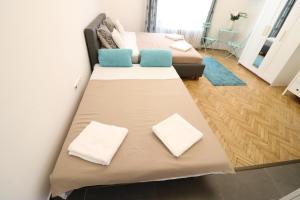 ブダペストにあるReal Apartments Wesselényi IIIのベッド2台とソファが備わる客室です。