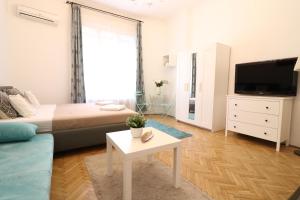 ブダペストにあるReal Apartments Wesselényi IIIのベッドルーム(ベッド1台、テレビ、テーブル付)