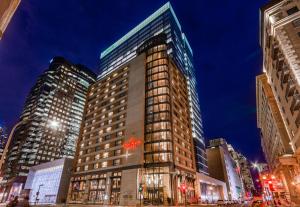 Un palazzo alto in una strada di città di notte di Le St-Martin Hotel Centre-ville – Hotel Particulier a Montréal