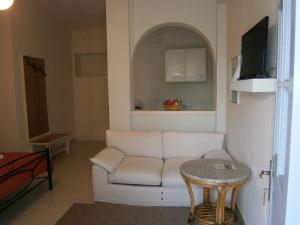 a living room with a white couch and a table at Theo Studios & Apartments in Spetses