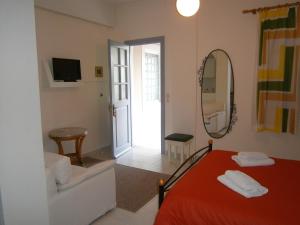 a bedroom with a red bed and a mirror at Theo Studios & Apartments in Spetses