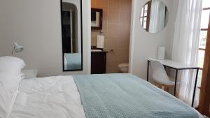 a bedroom with a bed and a bathroom with a mirror at Innes Road Durban Accommodation 2 bedroom private unit in Durban