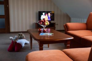 a little girl laying on the floor in a living room with a table at Hotel Panorama in Ostrowiec Świętokrzyski