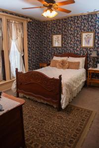a bedroom with a bed and a ceiling fan at Spencer House Bed & Breakfast in Erie