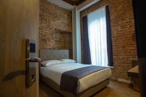 um quarto com uma cama e uma parede de tijolos em Jurnal Hotel em Istambul