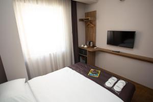 a hotel room with a bed and a flat screen tv at Jurnal Hotel in Istanbul