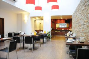 a restaurant with tables and chairs and a brick wall at Hotel California in Montevideo