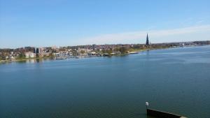 Une grande masse d'eau avec une ville en arrière-plan dans l'établissement Ferienwohnung NEXUS, à Schleswig