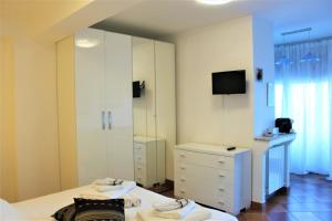 a bedroom with a white dresser and a mirror at Villa Sofia in Taormina