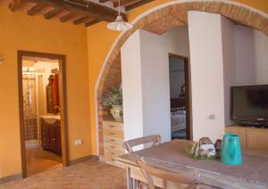 a kitchen and dining room with a table and a television at Podere Piandicava in Castelnuovo di Val di Cecina
