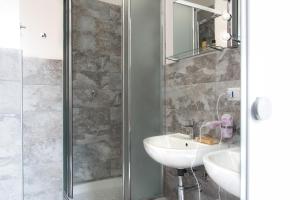 Un baño con lavabo, espejo y ducha. en Posada Verona Hostel, en Verona