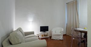 sala de estar con sofá, silla y TV en Mosca Cieca, en Florencia