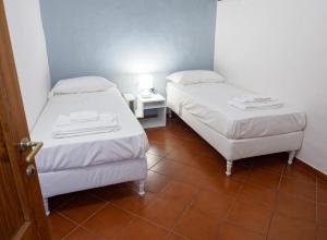 2 bedden in een kamer met een tegelvloer bij Mosca Cieca in Florence