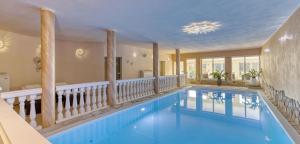 a swimming pool in a house with a balcony at Wellnesshotel deine Auszeit, Adults only in Achslach