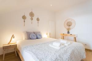 1 dormitorio con cama blanca y almohadas azules en Rato Cozy 3BR w/balcony - by LU Holidays, en Lisboa