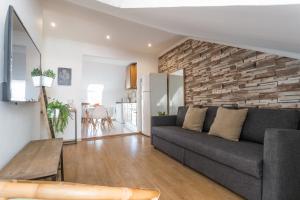 a living room with a couch and a brick wall at Rato Cozy 3BR w/balcony - by LU Holidays in Lisbon