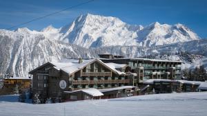 eine Ski-Lodge mit einem schneebedeckten Berg im Hintergrund in der Unterkunft Hotel Annapurna in Courchevel