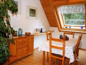 eine Küche mit einem Tisch und Stühlen sowie einem Fenster in der Unterkunft Hornihäusle in Aufʼm Bühl