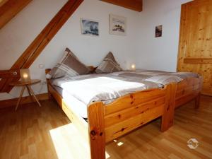 a bedroom with a wooden bed in a attic at Hornihäusle in Aufʼm Bühl