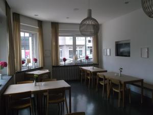 una sala da pranzo con tavoli, sedie e finestre di ART Hotel Ufer a Dusseldorf