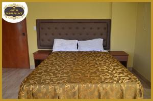 a bed in a hotel room with a gold bedspread at Dubai Palace in Lima