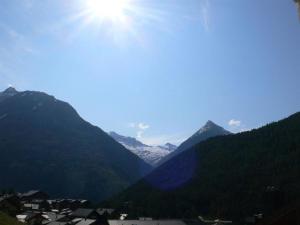 een uitzicht op een bergketen met de zon in de lucht bij Apartment Chalet Les Arolles by Interhome in Saas-Fee