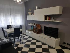 un soggiorno con TV e pavimento a scacchi di Appartamento Saretta ad Asti