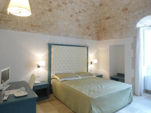 コンヴェルサーノにあるParco dei Manieriのベッドルーム1室(ベッド1台、テーブル2台、デスク付)