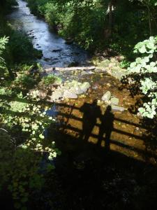 two people are standing in the shadows of a river at Ferienwohnung Boellsteiner Hoehe in Böllstein
