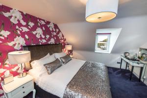 a bedroom with a bed with a floral wall at Shorehead Guest House in Stonehaven