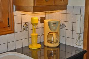 a kitchen counter with a yellow coffee maker and a phone at Villa Elegant in Periyiálion