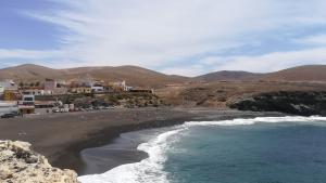 a beach with people on the sand and the ocean at Hostal-Private Room Descanso y Relax in Puerto del Rosario