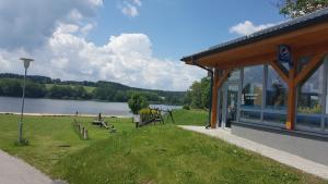 a building with a playground next to a lake at Lipno Apartmany Frymburk II. in Frymburk