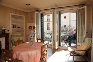 uma sala de jantar com uma mesa e uma mulher sentada numa varanda em Villa sainte claire em Amélie-les-Bains-Palalda