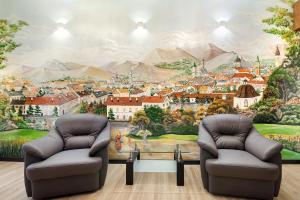a room with two chairs and a city mural at LEOGRAND Apartment on Doroshenka 38 in Lviv