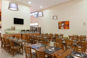 a dining room with wooden tables and chairs at Matiz Barão Geraldo Express Hotel in Campinas