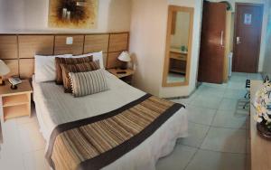 1 Schlafzimmer mit einem großen Bett und einem Badezimmer in der Unterkunft Hotel Nacional Inn São Carlos & Convenções in São Carlos