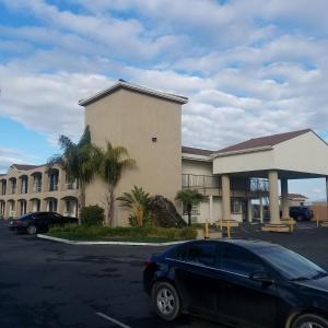 a black car parked in front of a building at SureStay Hotel by Best Western Hollister in Hollister