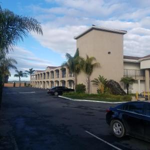 a building with cars parked in a parking lot at SureStay Hotel by Best Western Hollister in Hollister