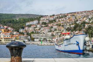 a boat is docked in the water near a city at Josephine Rabac in Rabac