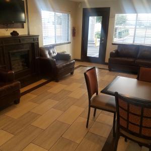 a living room with a fireplace and a table and chairs at SureStay Hotel by Best Western Hollister in Hollister