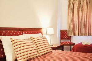 a hotel room with a bed with striped pillows at Casinha da Praia - Vila Nova de Gaia in Vila Nova de Gaia