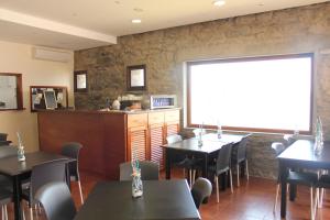 ein Restaurant mit Tischen und Stühlen und einem Fenster in der Unterkunft Hotel Vila Bela in Porto da Cruz