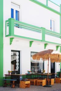 a restaurant with a table with an umbrella at Stressfree Apartamento in Vila Nova de Milfontes