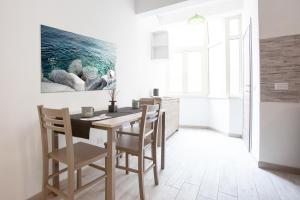 a dining room with a table and chairs and a painting at New Tiburtina in Rome