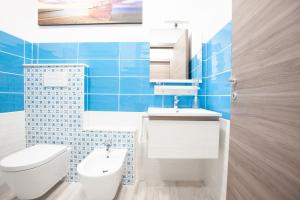 a blue tiled bathroom with a toilet and a sink at New Tiburtina in Rome +30 photos
