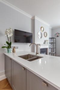 a kitchen with a sink and a white counter top at The Lempicka 2 Bedroom Flat and Garden in Notting Hill in London