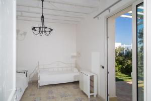 a white bedroom with a bed and a glass door at Casa Vacanza Casa nel Sole in Siracusa